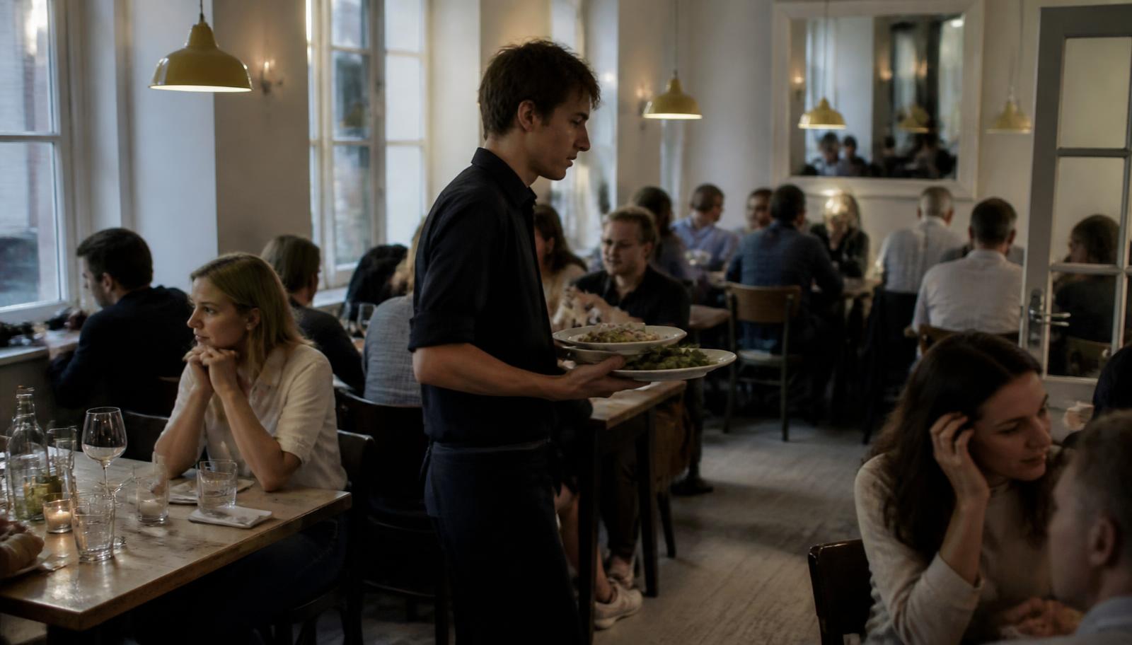 Restaurang med gäster där personalen serverar mat